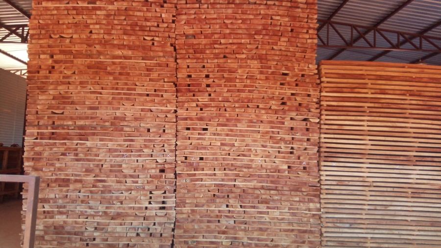Frente das pilhas de tábuas em tons de vermelho e palha, lado a lado